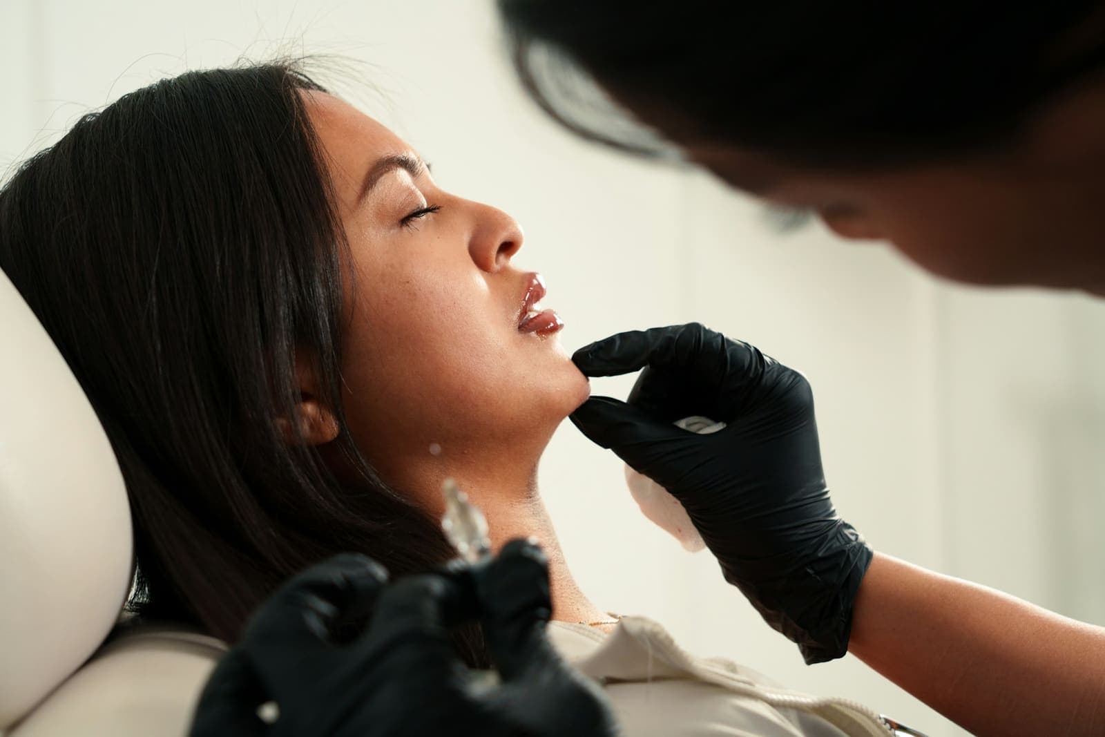 Client receiving a filler injection along the chin
