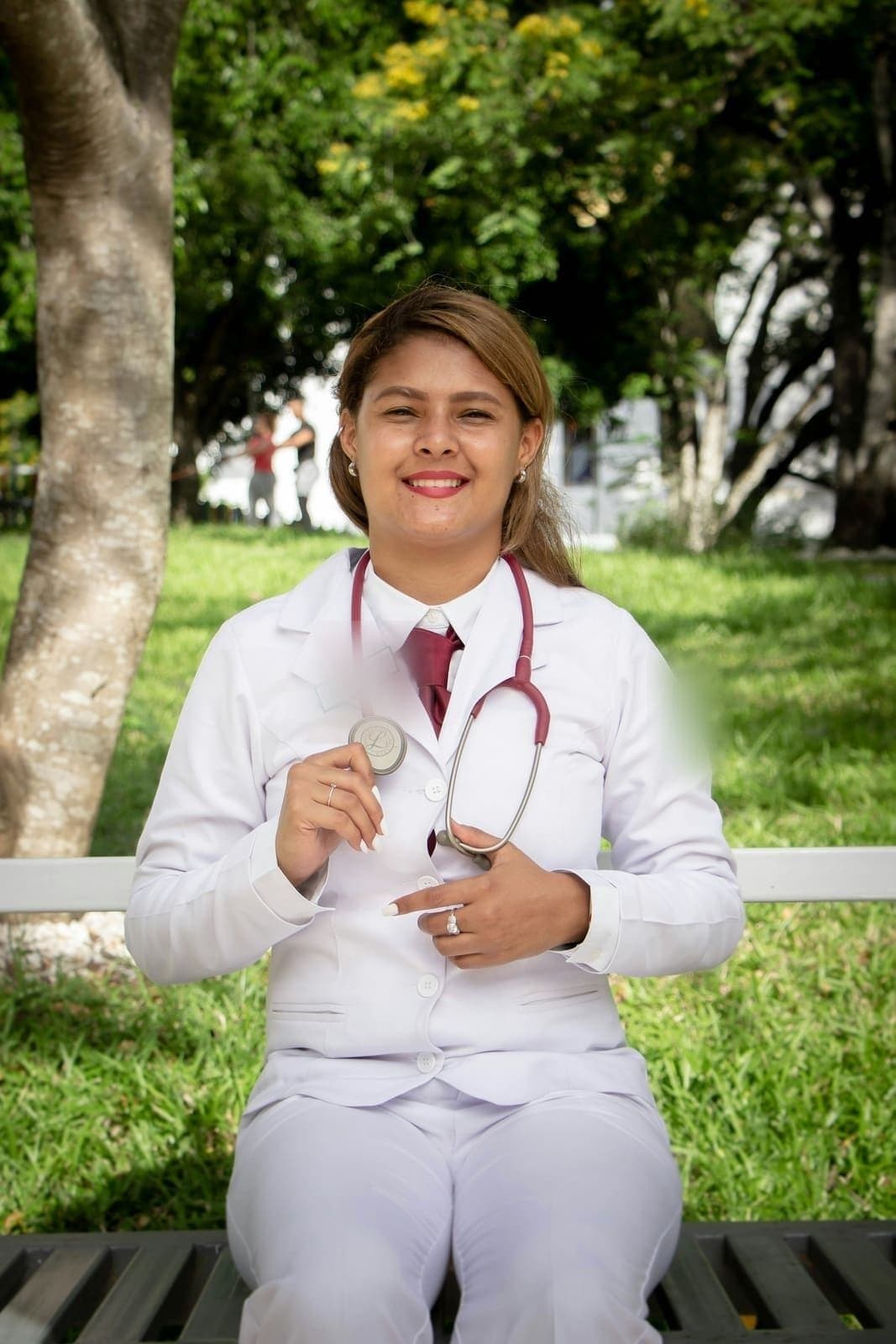 Smiling provider in a white coat holding a stethoscope