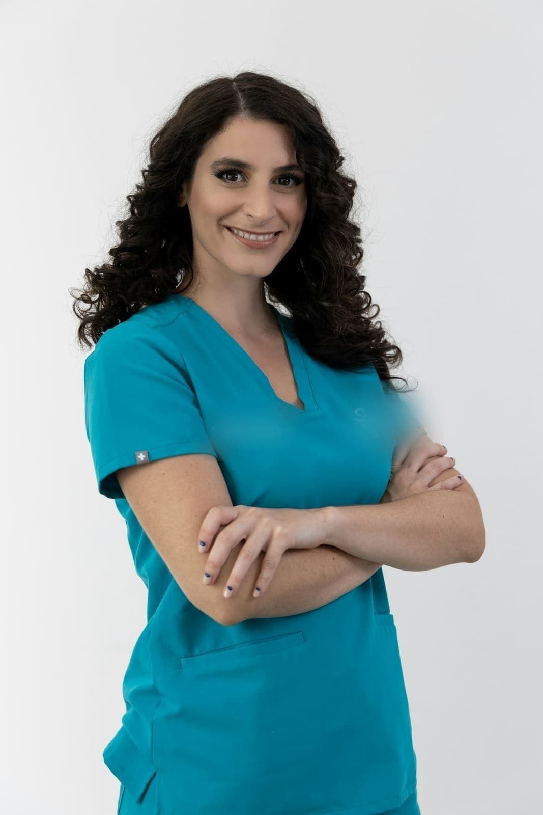 Provider in teal scrubs with arms crossed