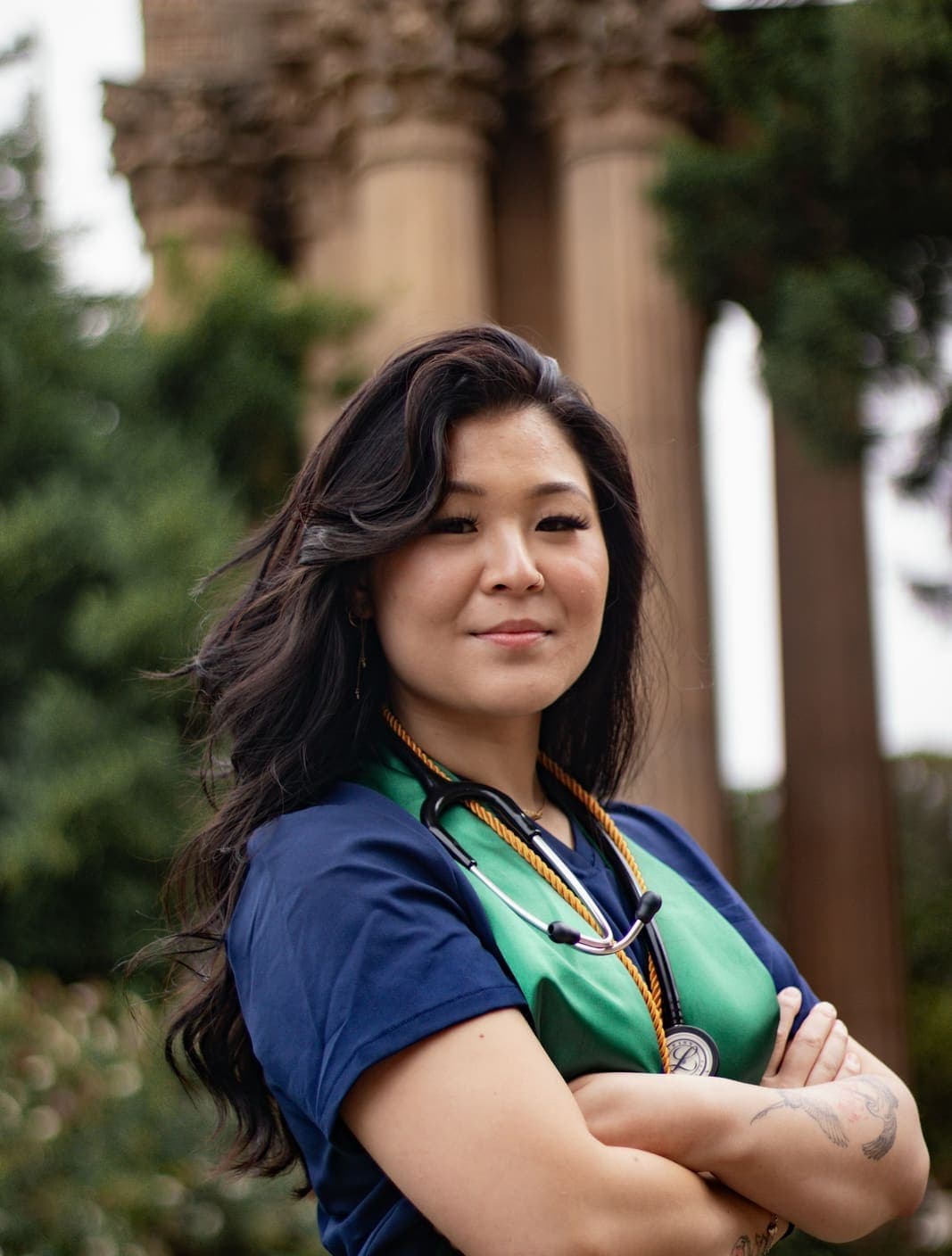 Provider in navy scrubs with a stethoscope, arms crossed