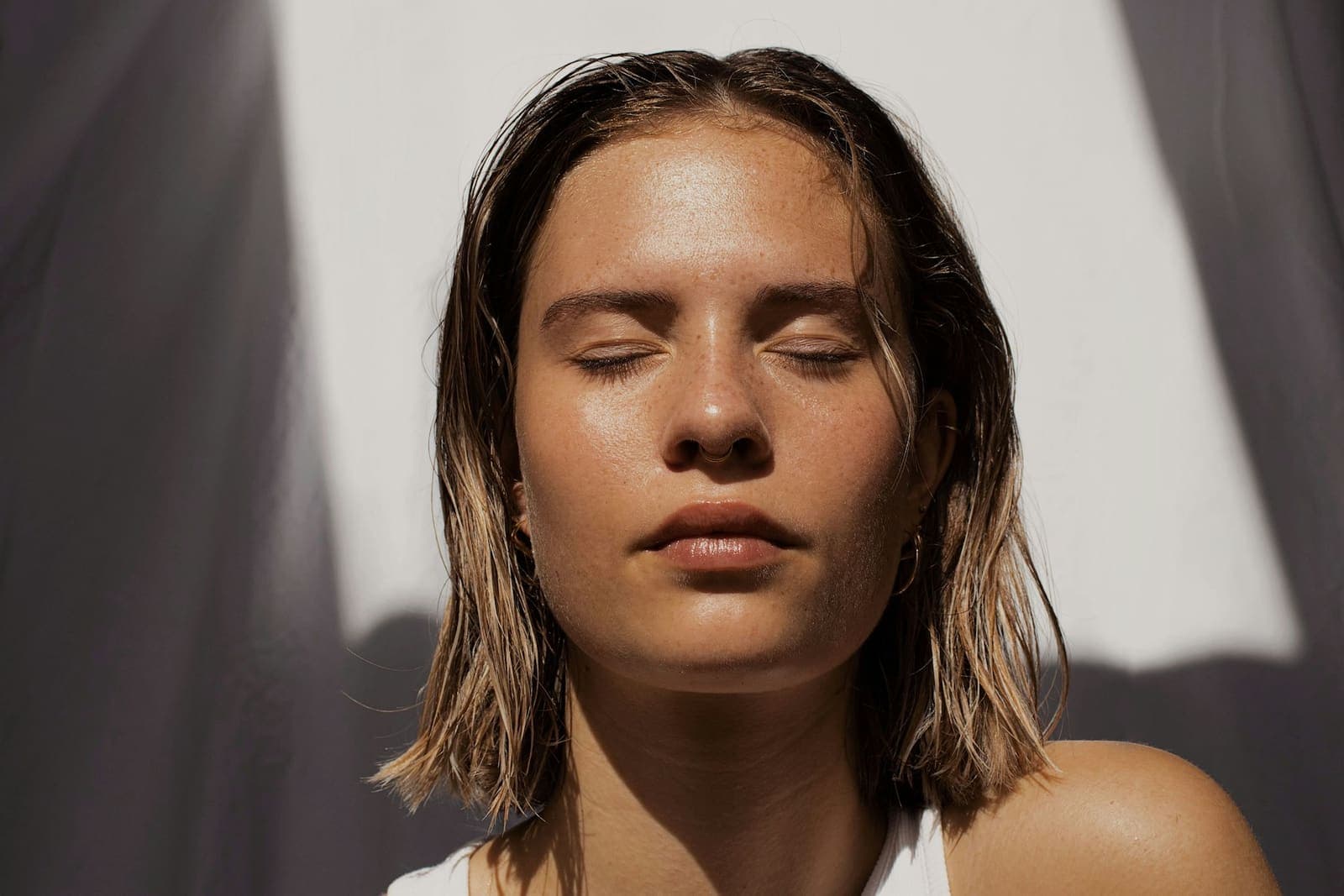 Woman with dewy skin and closed eyes in soft light